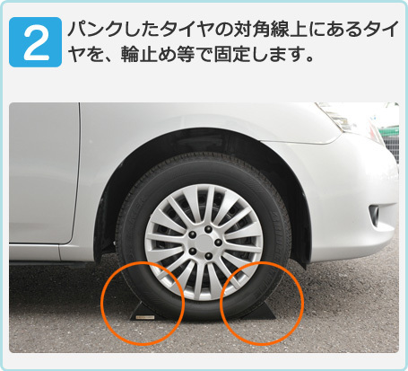 パンクしたタイヤの対角線上にあるタイヤを、輪止め等で固定します。