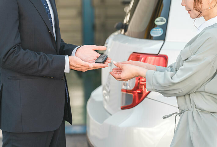 写真：女性から車の鍵を受け取る男性