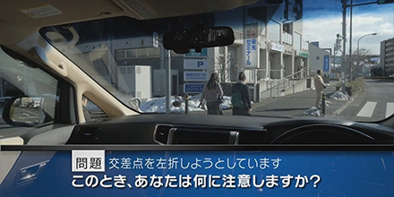 実写版危険予知「SCENE40 交差点編 その5 ～片側２車線ある道路をミニバンで走っています。信号機のある交差点を左折するため、歩行者の女性ふたりが横断歩道をわたり終えてから曲がろうと思います。～」