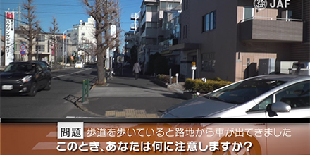 実写版危険予知「SCENE 39　歩行者編　その2　～歩道を歩いています。 路地から幹線道路に左折する車が出てきましたが、停止したので、その前を通過しようと思います。～」