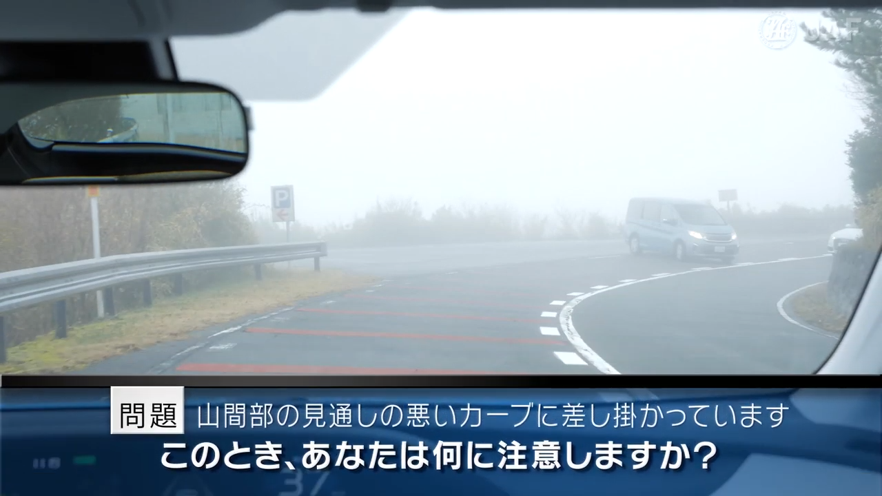 実写版危険予知「SCENE57　カーブ編 その4 ～視界が悪い山間部の道路を走っています。見通しの悪いカーブに差し掛かり、左側には駐車場があります。～」