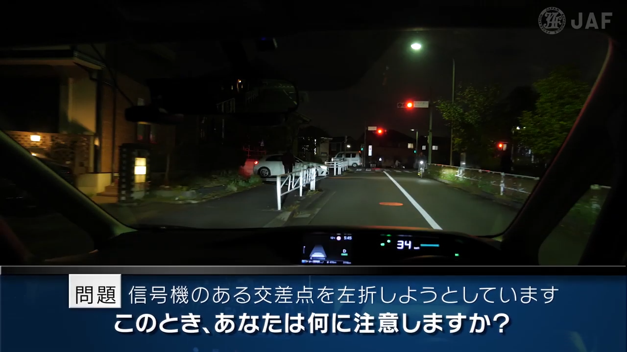 実写版危険予知「SCENE56　交差点編 その9 ～前方の信号機のある交差点に向かって走っています。信号が赤なので停止線で止まりますが、左折するために合図を出しています。～」
