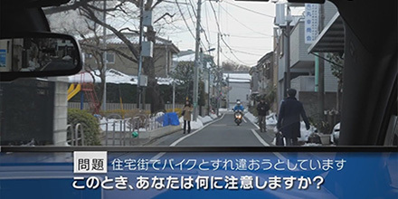 実写版 危険予知トレーニング-SCENE41 住宅街編 その4 道幅の狭い住宅街を走行しています。左右には歩行者が歩いており、前方からバイクが来ているので、少し左側に寄ってすれ違おうと思います。