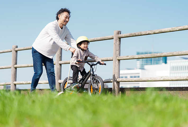 自転車に乗る練習をする親子