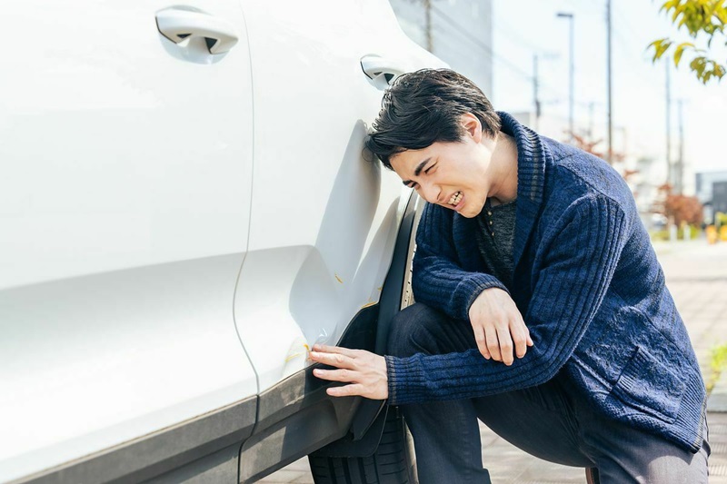 クルマの傷を確認する男性